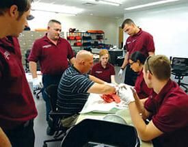 instructer teaching students around a stretcher